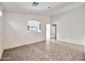 Spacious living room with neutral walls, tile floors and open archway into the kitchen at 11765 W Maui Ln, El Mirage, AZ 85335