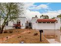 Charming home showcasing terra cotta roof, decorative iron gate, and a well-manicured, low-maintenance yard at 120 E Calavar Rd, Phoenix, AZ 85022