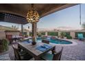 Inviting outdoor patio with dining area overlooking a pool and lush landscaping at 12231 S 185Th Ave, Goodyear, AZ 85338