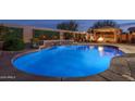 Backyard swimming pool with integrated waterfall feature and fire pit under a gazebo at 12231 S 185Th Ave, Goodyear, AZ 85338