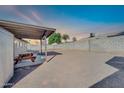 View of covered patio with picnic table overlooking expansive backyard and block wall at 1430 W Rockwood Dr, Phoenix, AZ 85027