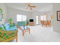 Bright living room featuring tropical-patterned sofas, ceiling fan, and a dining area at 145 N 74Th St # 256, Mesa, AZ 85207