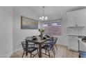 Dining room with modern chandelier, decorative painting, and table set for six at 16611 N 19Th St, Phoenix, AZ 85022