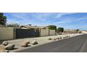 View of desert landscaping in front yard, large rock decorations, and iron fence at 18224 N 70Th Ave, Glendale, AZ 85308