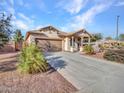 Single-story home with desert landscaping, long driveway, and attached garage at 18556 W Vogel Ave, Goodyear, AZ 85338