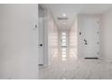 Bright hallway with white marble tile floors, leading to a modern glass-panel front door at 21743 N Daniel Dr, Maricopa, AZ 85138