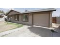 Single-story house with a well-kept lawn, a two-car garage, and neutral exterior paint at 2201 W Wethersfield Rd, Phoenix, AZ 85029