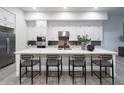 Bright kitchen showcasing a large island with seating, white cabinetry, and stainless steel appliances at 23880 N 127Th St, Scottsdale, AZ 85255