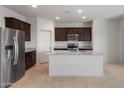 Modern kitchen with stainless steel appliances and granite countertops on a large island at 25154 W Wier Ave, Buckeye, AZ 85326