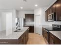 Spacious kitchen featuring stainless steel appliances, granite countertops, and dark wood cabinets at 25154 W Wier Ave, Buckeye, AZ 85326