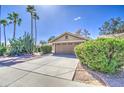 Charming home with desert landscaping featuring mature trees, a two-car garage, and a well-kept driveway at 2560 S Rowen --, Mesa, AZ 85209