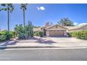 Well-maintained home with desert landscaping featuring mature trees, a two-car garage, and a wide driveway at 2560 S Rowen --, Mesa, AZ 85209