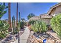 Well-maintained walkway showcasing desert landscaping with rocks and cacti leading to front entrance at 2560 S Rowen --, Mesa, AZ 85209