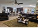 Open-concept living room with modern kitchen, breakfast bar, and sleek stainless steel appliances at 2678 S 172Nd Dr, Goodyear, AZ 85338