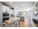 A bright kitchen with white cabinets, stainless steel appliances, and a granite-topped island at 2741 E Bridgeport Pkwy, Gilbert, AZ 85295