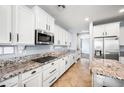 A modern kitchen features white cabinets, granite countertops, stainless steel appliances, and ample cabinet space at 2741 E Bridgeport Pkwy, Gilbert, AZ 85295