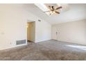 Bright living room featuring vaulted ceilings, plush carpet, and skylight at 3001 E Amber Ridge Way, Phoenix, AZ 85048