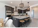 Modern kitchen features a large island with seating, stainless steel appliances, and stylish pendant lighting at 33402 N 142Nd Way, Scottsdale, AZ 85262