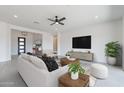 Bright living room features modern furnishings, a ceiling fan, and sleek entertainment center at 33402 N 142Nd Way, Scottsdale, AZ 85262