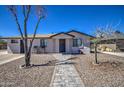 Adorable single-story home with xeriscaping and a paved pathway to the entrance at 350 S Thunderbird Dr, Apache Junction, AZ 85120