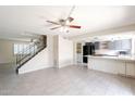 Spacious living area with tile floors leading to staircase and kitchen with breakfast bar at 3823 N 28Th St, Phoenix, AZ 85016
