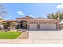 Charming single-story home showcasing a well-manicured lawn, desert landscaping, and a spacious three-car garage at 5929 W Riviera Dr, Glendale, AZ 85304