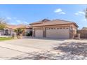 Spacious three-car garage with tile roof and desert landscaping at 5929 W Riviera Dr, Glendale, AZ 85304