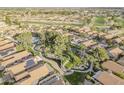 Picturesque aerial view of a community with lush landscaping, winding waterways, and solar panels at 9409 W Taro Ln, Peoria, AZ 85382