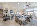 Bright, open-concept living area with vaulted ceiling, tile floors, and large sectional sofa at 9409 W Taro Ln, Peoria, AZ 85382