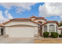 Traditional home featuring desert landscaping, arched entry, tile roof, and two-car garage at 9632 W Runion Dr, Peoria, AZ 85382