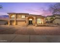 Elegant home featuring a stately exterior with arched entryway, manicured landscaping, and a three-car garage at 9686 W Keyser Dr, Peoria, AZ 85383