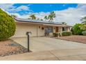 Single-story home with solar panels, desert landscaping, and attached two-car garage at 9918 W Willow Creek Cir, Sun City, AZ 85373