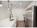 Bright kitchen featuring stainless steel appliances, white cabinets, a large island with sink, and modern pendant lighting at 11605 W Green Dr, Youngtown, AZ 85363