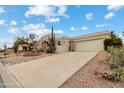 View of the front exterior of a desert-landscaped home with a circular fountain in the front yard at 15440 E Mustang Dr, Fountain Hills, AZ 85268