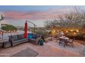 Outdoor patio featuring cozy seating, a table, and a vibrant umbrella, ideal for relaxing and enjoying mountain views at 15510 E Sycamore Dr, Fountain Hills, AZ 85268