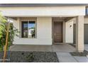 Welcoming front porch with neutral colors, desert landscaping, and a stylish front door at 15675 W Mercer Ln, Surprise, AZ 85379