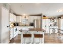 Kitchen with island, bar stool seating, white cabinetry, and stainless steel appliances at 1669 N Suncrest Ave, Casa Grande, AZ 85122