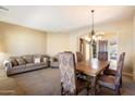 Inviting living room with carpeted floors, a large dining table, and warm, neutral tones at 1708 W Dusty Wren Dr, Phoenix, AZ 85085