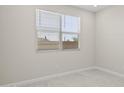 Neutral bedroom featuring gray flooring and a large window with bright light at 17735 W Brown St, Waddell, AZ 85355