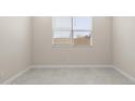 Bright bedroom with gray floors, a window with blinds, and neutral walls at 17735 W Brown St, Waddell, AZ 85355