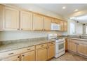 A kitchen featuring wooden cabinets, granite countertops, and modern appliances, including a white gas range at 1828 W Hemingway Ln, Anthem, AZ 85086