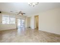 Bright living room with tile floors, a ceiling fan, large windows and sliding glass doors to the backyard at 1828 W Hemingway Ln, Anthem, AZ 85086