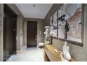 Elegant hallway with textured wallpaper, modern art, and an elevator for easy access at 18720 N 101St St # 3021, Scottsdale, AZ 85255