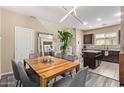 Elegant dining area boasts a wooden table, modern lighting, and an adjacent kitchen, ideal for entertaining at 2013 N 77Th Gln, Phoenix, AZ 85035