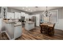 Bright kitchen with white cabinetry, stainless steel appliances, center island, and hardwood flooring, perfect for cooking and entertaining at 20916 E Desert Hills Blvd, Queen Creek, AZ 85142