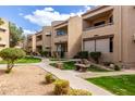 Charming exterior view of building with beautiful landscaping, grass, trees and walkways at 2228 N 52Nd St # 117, Phoenix, AZ 85008