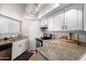 Well-lit kitchen features granite countertops and white cabinetry at 2228 N 52Nd St # 117, Phoenix, AZ 85008