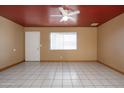 A bright living room with neutral walls, ceiling fan and tile flooring, creating a comfortable living space at 2928 W Cactus Rd, Phoenix, AZ 85029