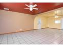 Bright, open living room with tile floors, neutral walls, ceiling fan, and access to other areas of the home at 2928 W Cactus Rd, Phoenix, AZ 85029