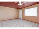 A bright living room with neutral walls, ceiling fan and tile flooring, creating a comfortable living space at 2928 W Cactus Rd, Phoenix, AZ 85029